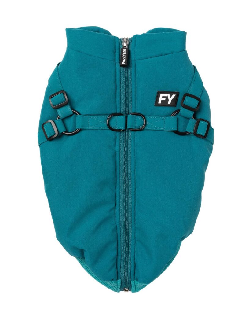 La imagen muestra un chaleco o arnés para perros de color verde menta con un diseño acolchado y una cremallera en el centro, que lleva una etiqueta que dice "FuzzYard" en el tirador. El chaleco tiene dos correas ajustables con hebillas negras a cada lado y dos anillos en "D" de metal en el centro para sujetar una correa. También presenta un parche con las letras "FY" en el lado derecho. Este chaleco no solo ofrece un estilo moderno y funcional, sino que también subraya los beneficios de la ropa para perros, al proporcionar comodidad y seguridad mientras tu mascota luce elegante.